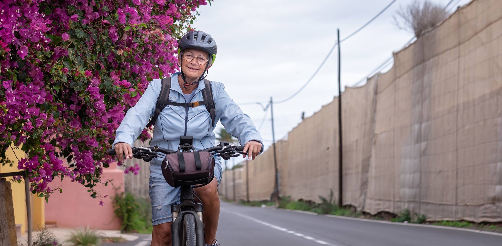 AvD Artikel - Ältere Frau fährt glücklich mit Ihrem E-Bike.